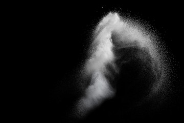 White powder explosion isolated on black background. White dust particles splash.Color Holi...