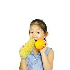 little girl holding fresh orange and sweet corn