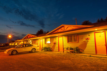 Typical small clean motel with parking lot at night, Canada