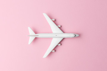 White plane on pink background closeup. Travel and adventures concept