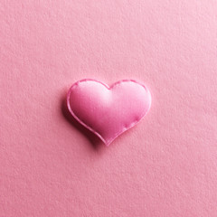Fototapeta premium Pink textile heart on pink background. Valentines day texture and love concept