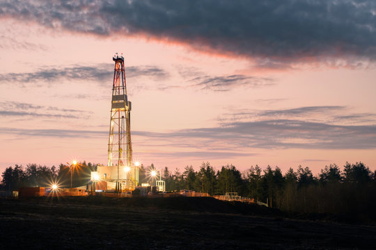 Oil Gas Drilling Rig On Sunset Background. Industrial Concept