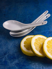 LIMONES AMARILLOS CORTADOS CON CUCHARAS BLANCAS DE PORCELANA