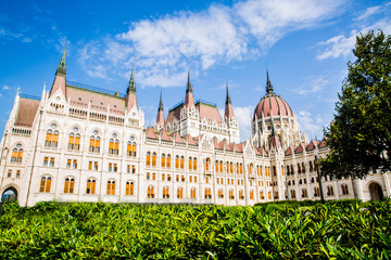 Fototapeta premium Budapest Parliament facade and bright green grass, Hungary. Summertime.