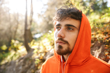 Handsome young sports fitness man runner outdoors in park.