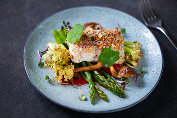 Halibut with hazelnut crust with roast red pepper sauce, asparagus, cauliflower and shiitake mushrooms