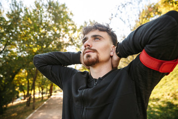 Obraz premium Handsome young sports fitness man runner outdoors in park