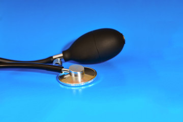 Tonometer and stethoscope for measuring pressure in hypertension and heart disease, on a blue...