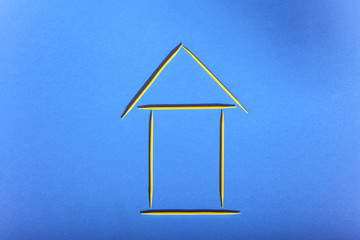 House of toothpicks on a blue background, concept of affordable housing