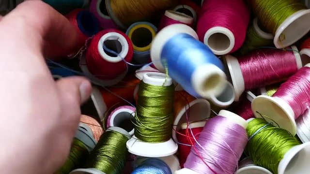 a person trying to choose a handmade rope, colored handwork ropes, in a box,