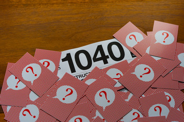 Fototapeta na wymiar Question mark heap and Income Tax Return Form 1040 on desk