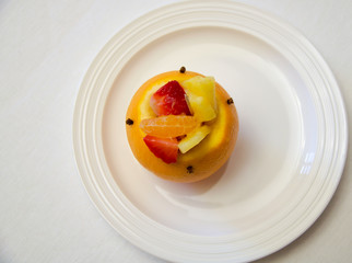 one stuffed orange with mixed fruit salad on a white dish