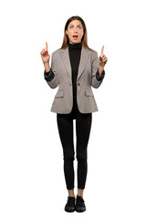 A full-length shot of a Business woman surprised and pointing up over isolated white background