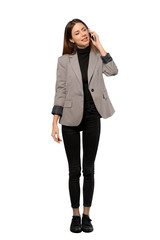 Fototapeta premium A full-length shot of a Business woman keeping a conversation with the mobile phone over isolated white background