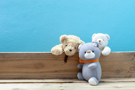Teddy bear on old wood ,blue wall background