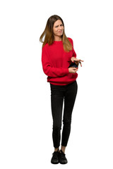 A full-length shot of a Young woman with red sweater holding a wallet over isolated white background