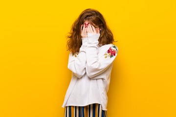 Young redhead woman over yellow wall with tired and sick expression