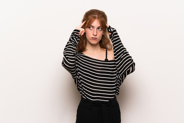 Young redhead woman over white wall having doubts and thinking