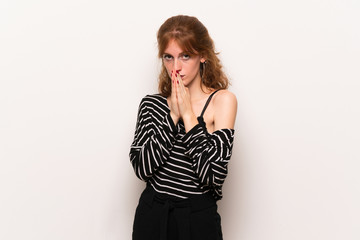 Fototapeta premium Young redhead woman over white wall keeps palm together. Person asks for something