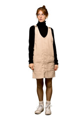 Fototapeta premium A full-length shot of a Young redhead woman looking up with serious face over isolated white background