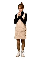 A full-length shot of a Young redhead woman scheming something over isolated white background