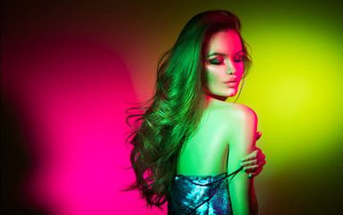 Fashion model brunette woman in colorful bright neon lights posing in studio. Beautiful sexy girl, trendy. Art design colorful makeup