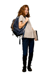 A full-length shot of a Young redhead student posing with arms at hip and laughing over isolated white background