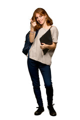 A full-length shot of a Young redhead student points finger at you with a confident expression over isolated white background