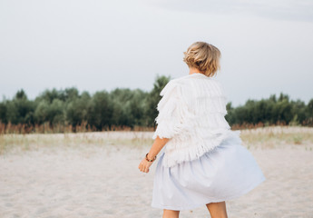 girl walks along sand direction trees rejoices