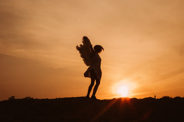woman top mountain rejoices dances sunset