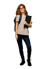 A full-length shot of a Young redhead student with glasses and happy over isolated white background