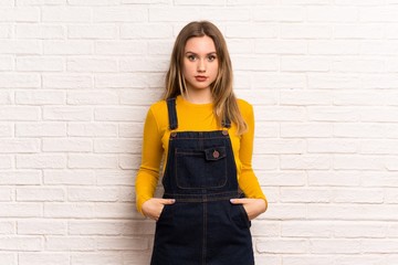 Teenager girl over white brick wall portrait