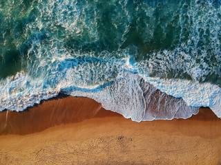 Aerial view of sandy beach with waves and clear ocean water. Drone photo - Powered by Adobe