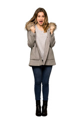 A full-length shot of a Teenager girl with coat celebrating a victory in winner position on isolated white background