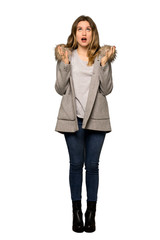 A full-length shot of a Teenager girl with coat frustrated by a bad situation on isolated white background