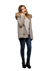 A full-length shot of a Teenager girl with coat making phone gesture. Call me back sign on isolated white background