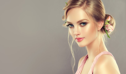 Beautiful model girl  with elegant hairstyle and rose flowers in a plait . Woman with fashion ...