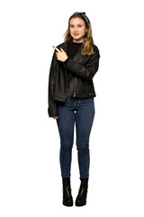 A full-length shot of a Teenager girl with leather jacket pointing to the side to present a product on isolated white background