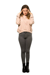 A full-length shot of a Teenager girl with pink sweater with headache over isolated white background