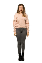A full-length shot of a Teenager girl with pink sweater with surprise facial expression over isolated white background