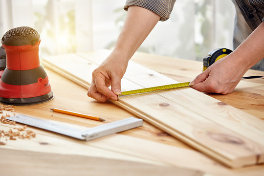 Carpenter works with wood in the workshop. A woman works in a carpentry workshop.