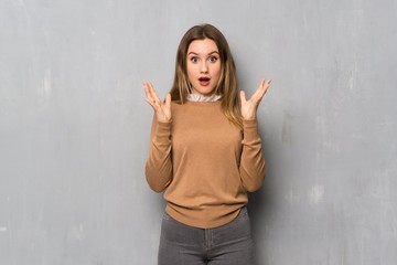 Teenager girl over textured wall with shocked facial expression