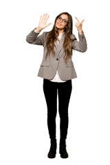 Full-length shot of Business woman counting seven with fingers on isolated white background