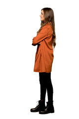 Full-length shot of Young woman with coat in lateral position on isolated white background