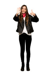 Obraz na płótnie Canvas Full-length shot of Young woman with leather jacket showing ok sign with and giving a thumb up gesture on isolated white background
