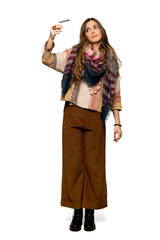 Full-length shot of Young hippie woman listening music with the phone on isolated white background