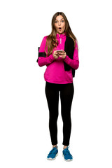 Full-length shot of Young sport woman surprised and sending a message over isolated white background