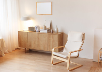 Fototapeta na wymiar Modern minimalistic interior with chest of drawers an braided armchair. Scandinavian style.