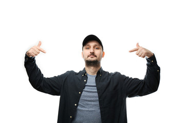 Fashionable white man with beard and cap points to himself.