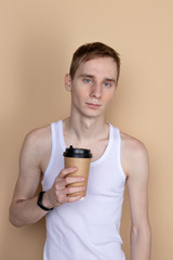Skinny handsome guy drink from coffee or tea cup. Morning refreshment and drink